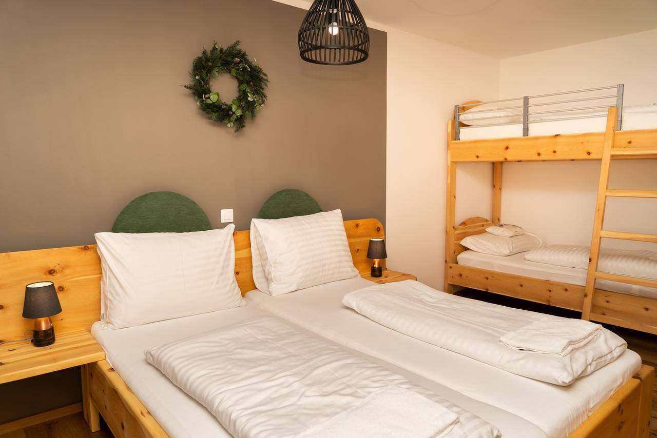 Bedroom with double bed and bunk bed – Almzeit chalet apartment, Turracher Höhe