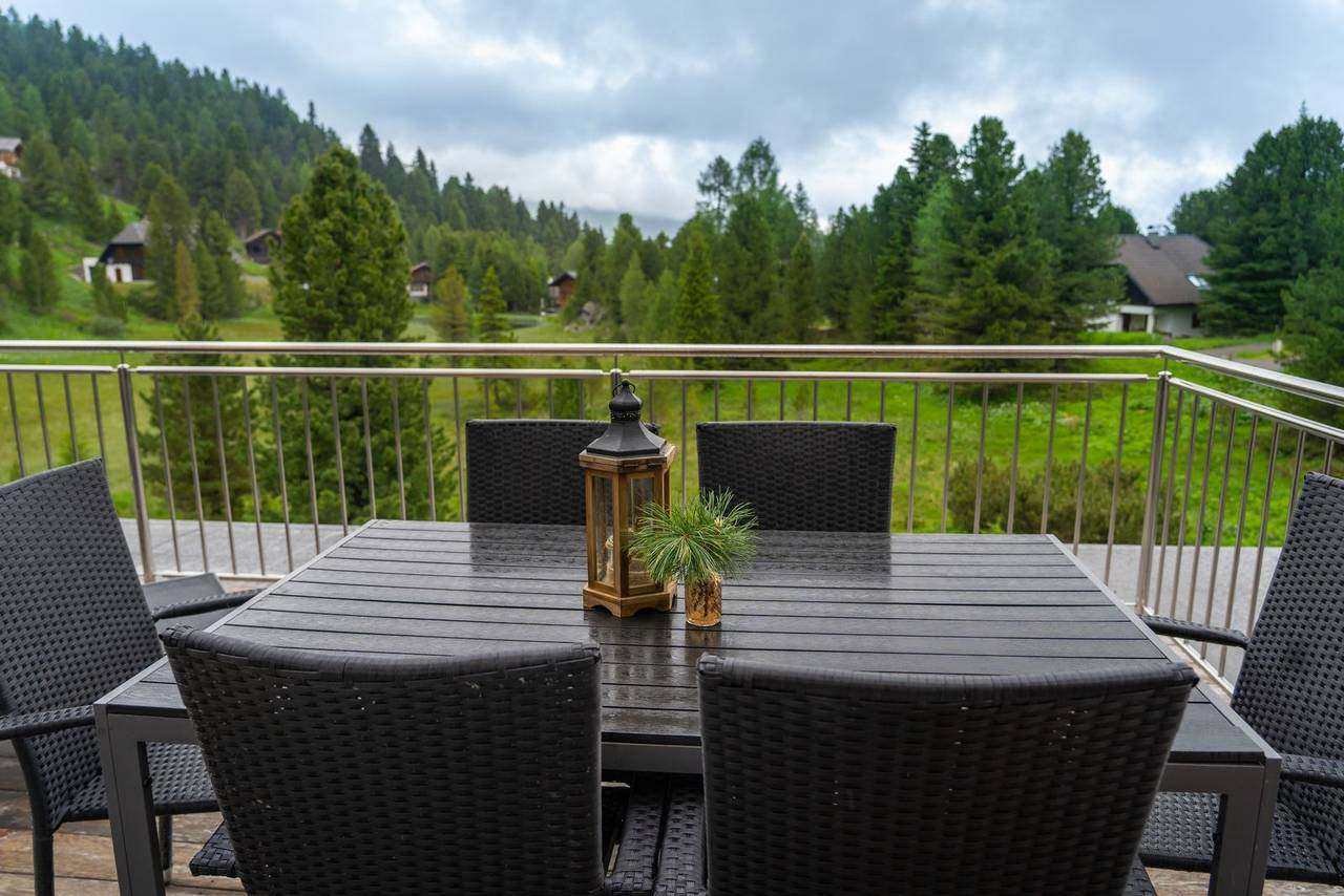 Private terrace with dining table and views of forest and pastures – Almzeit chalet apartment, Turracher Höhe