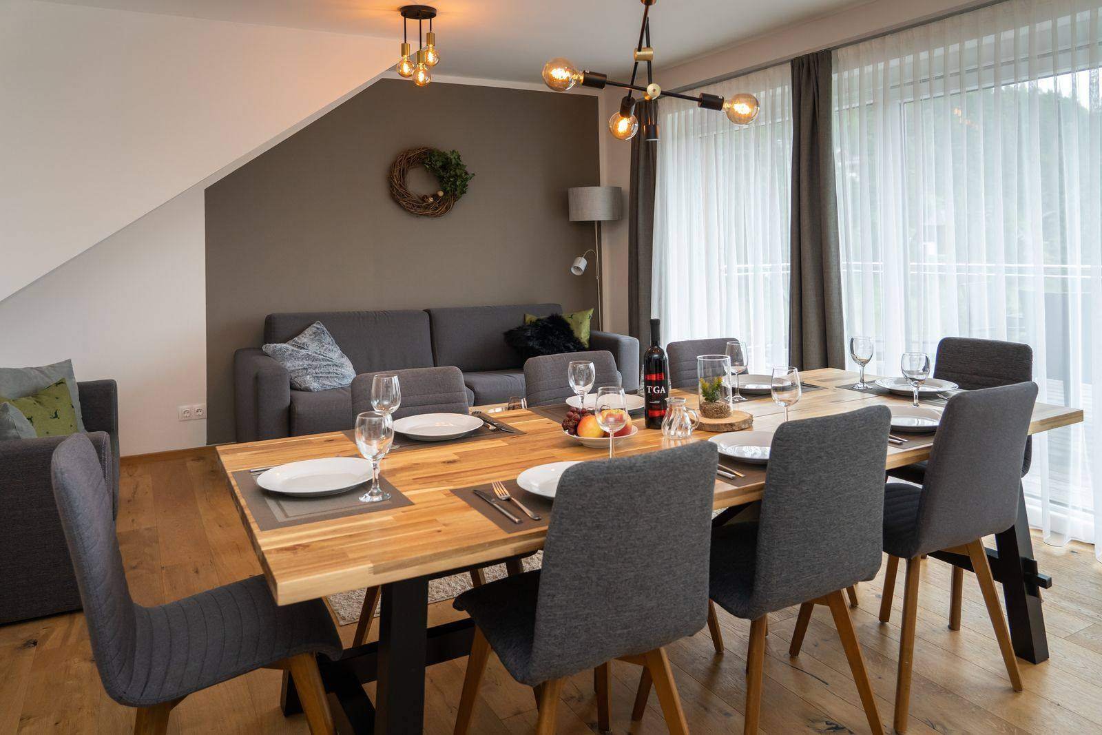 Living and dining area with a large table – Almzeit chalet apartment, Turracher Höhe