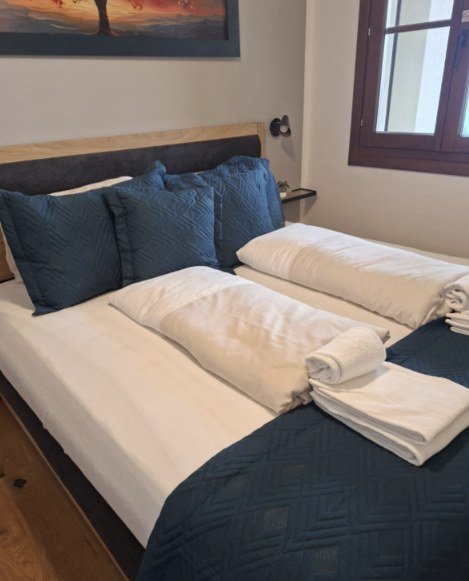 Bedroom with double bed and window – holiday apartment Alpenblick, Gerlitzen Alpe