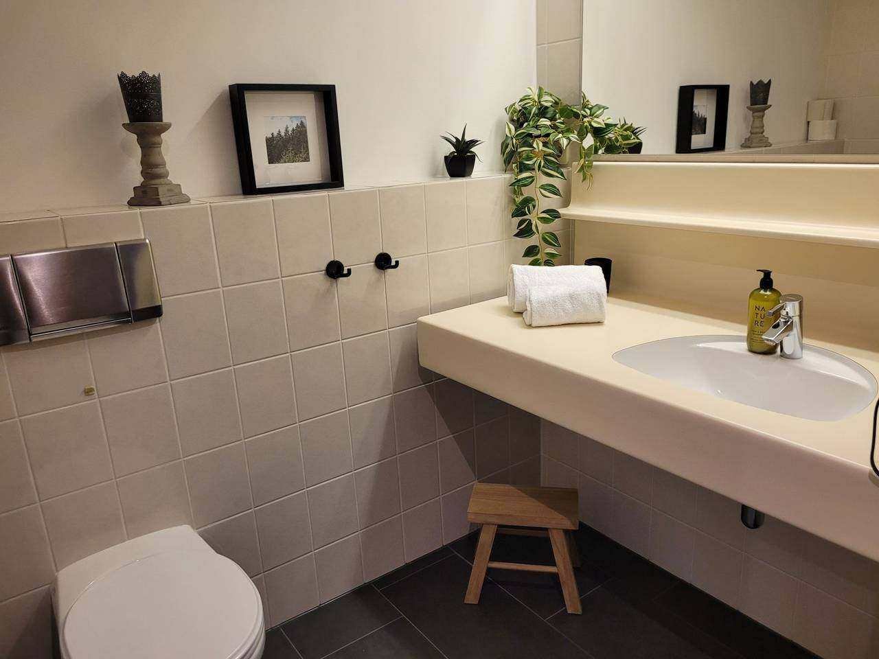 Bathroom with vanity, toilet and towels – holiday apartment Gerlitzen Alpe