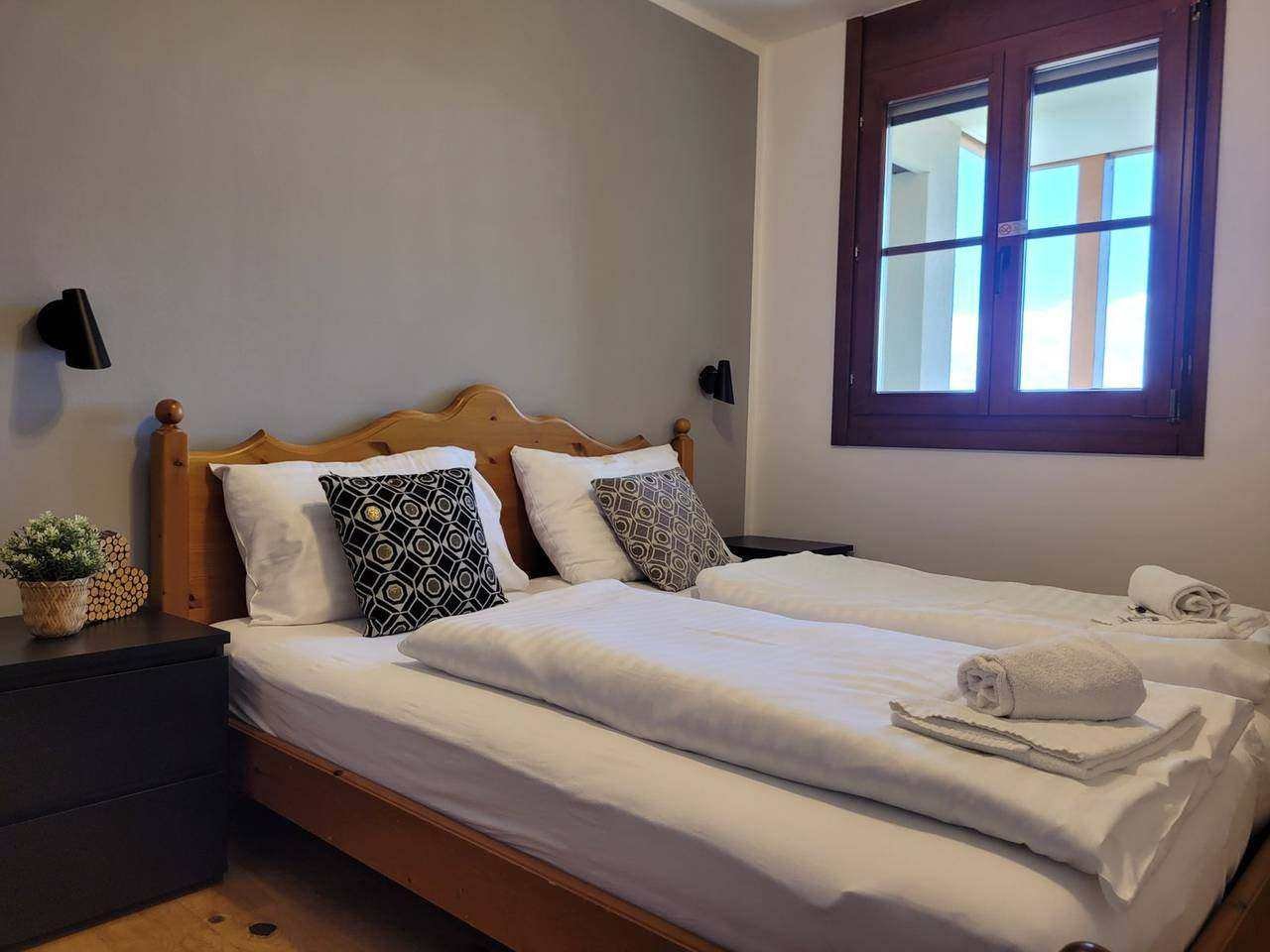 Bedroom with double bed and window – holiday apartment Gerlitzen Alpe
