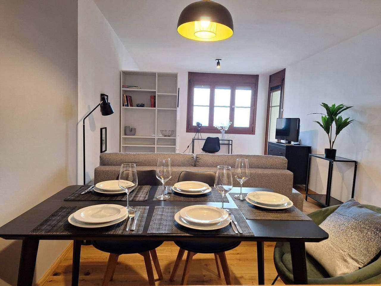 Living and dining area with set table, sofa and windows – holiday apartment Gerlitzen Alpe