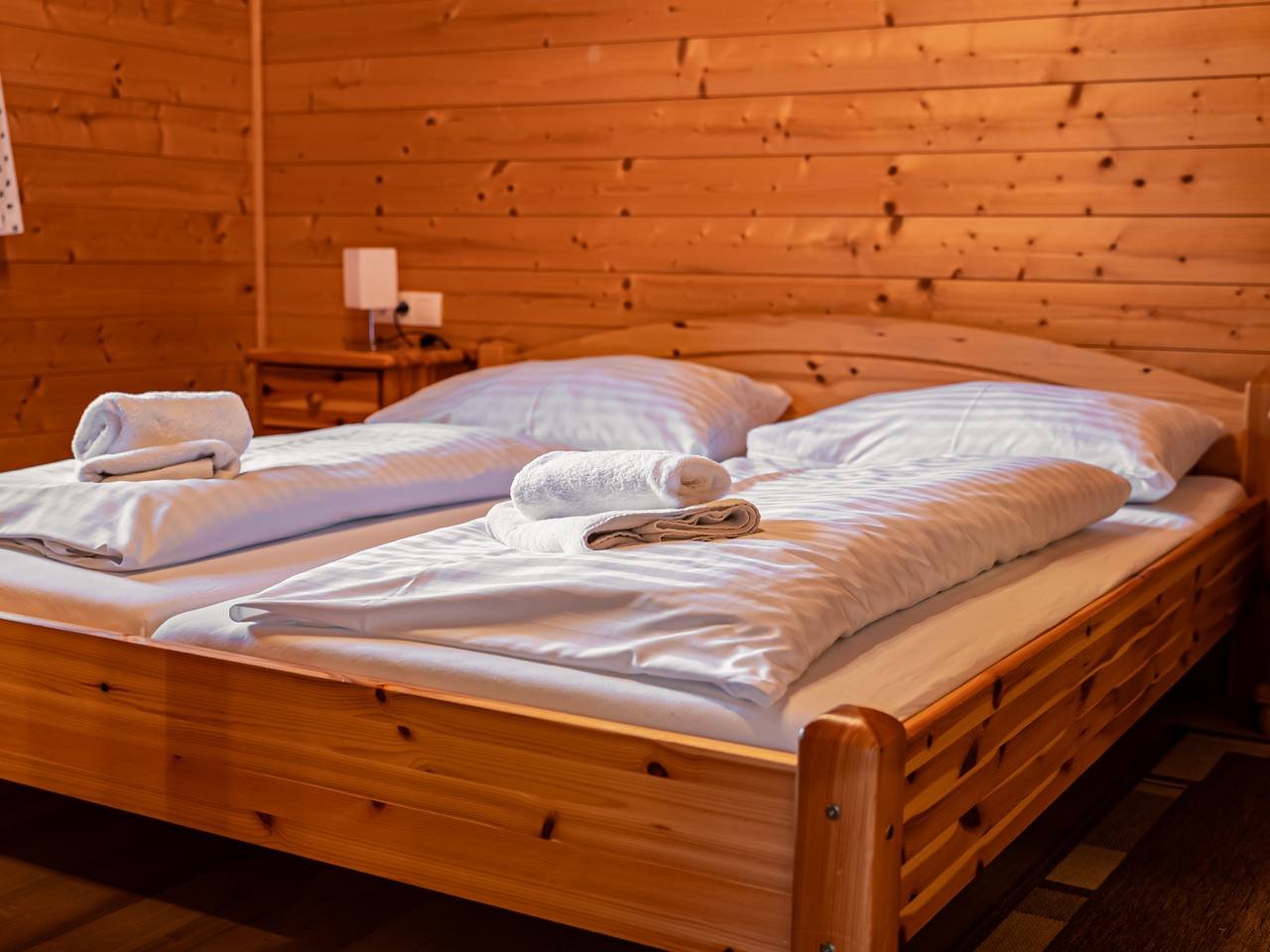 Bedroom with wooden double bed – Chalet Murmeltier