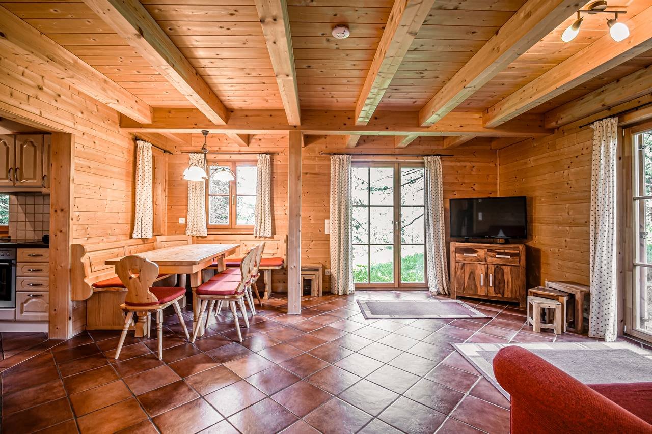Living room with timber ceiling and dining table – Chalet Haus Murmeltier, Turracher Höhe