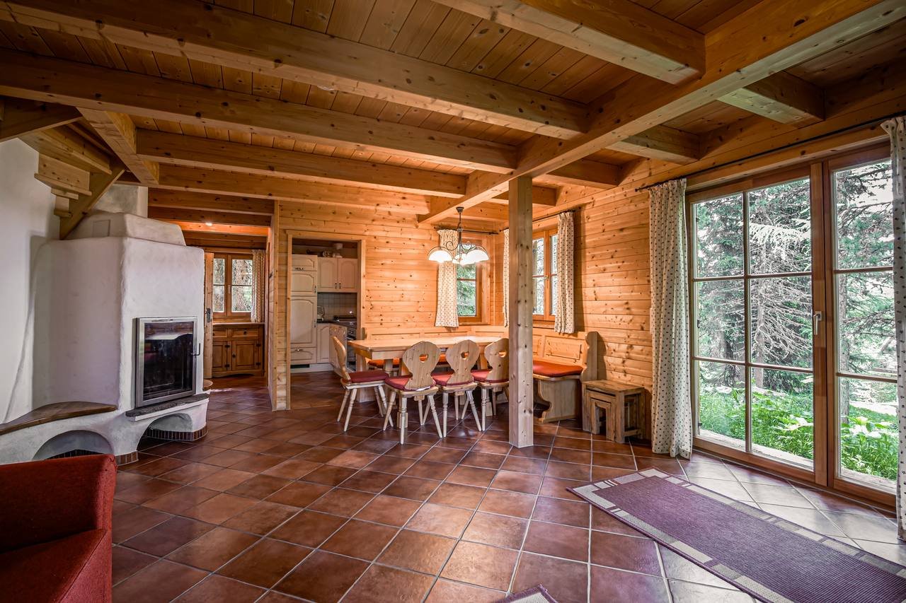 Living room with tiled stove and garden view – Chalet Murmeltier