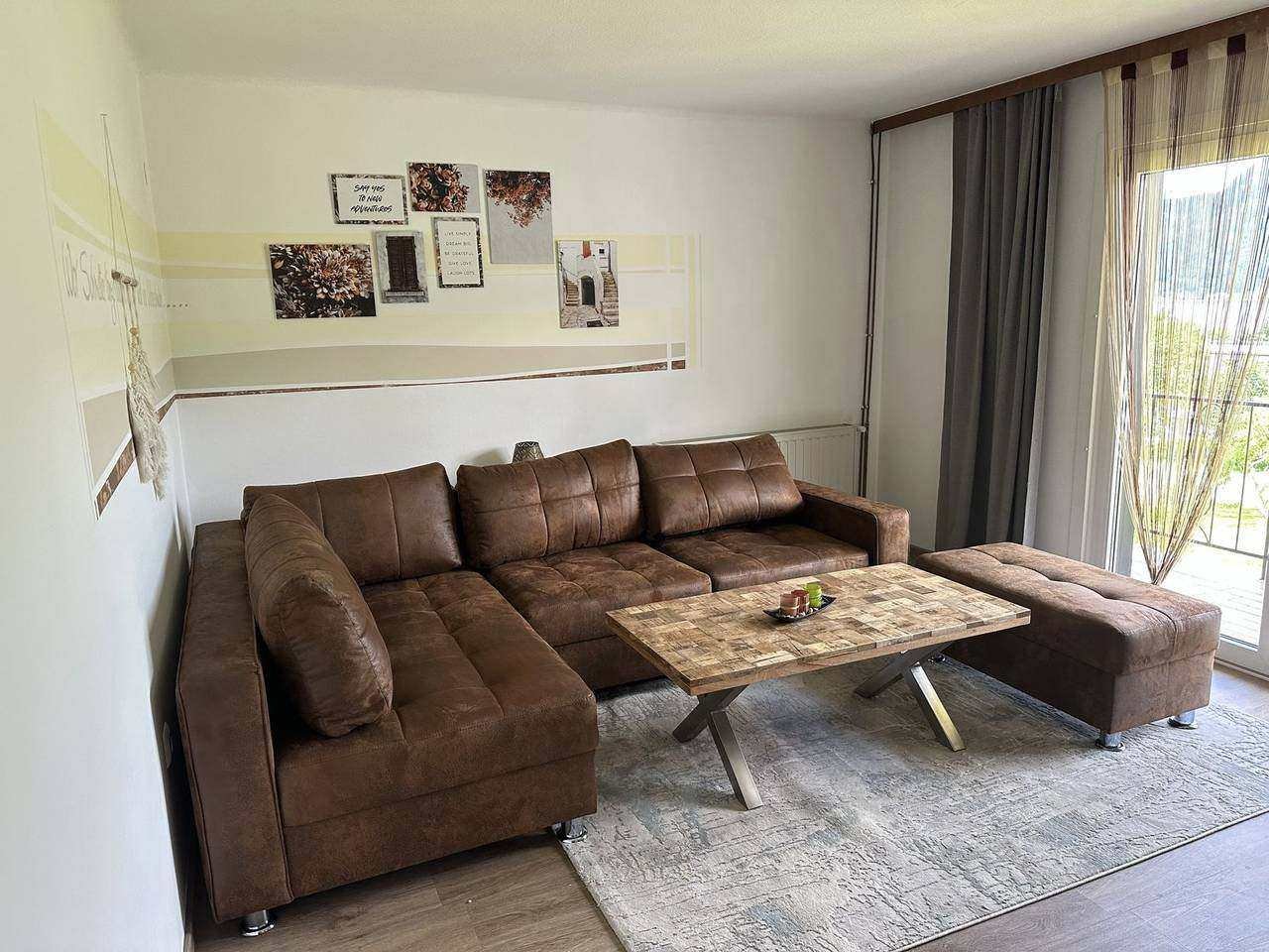 Living room with corner sofa and balcony door – Ossiachersee apartment (ground floor), Sattendorf